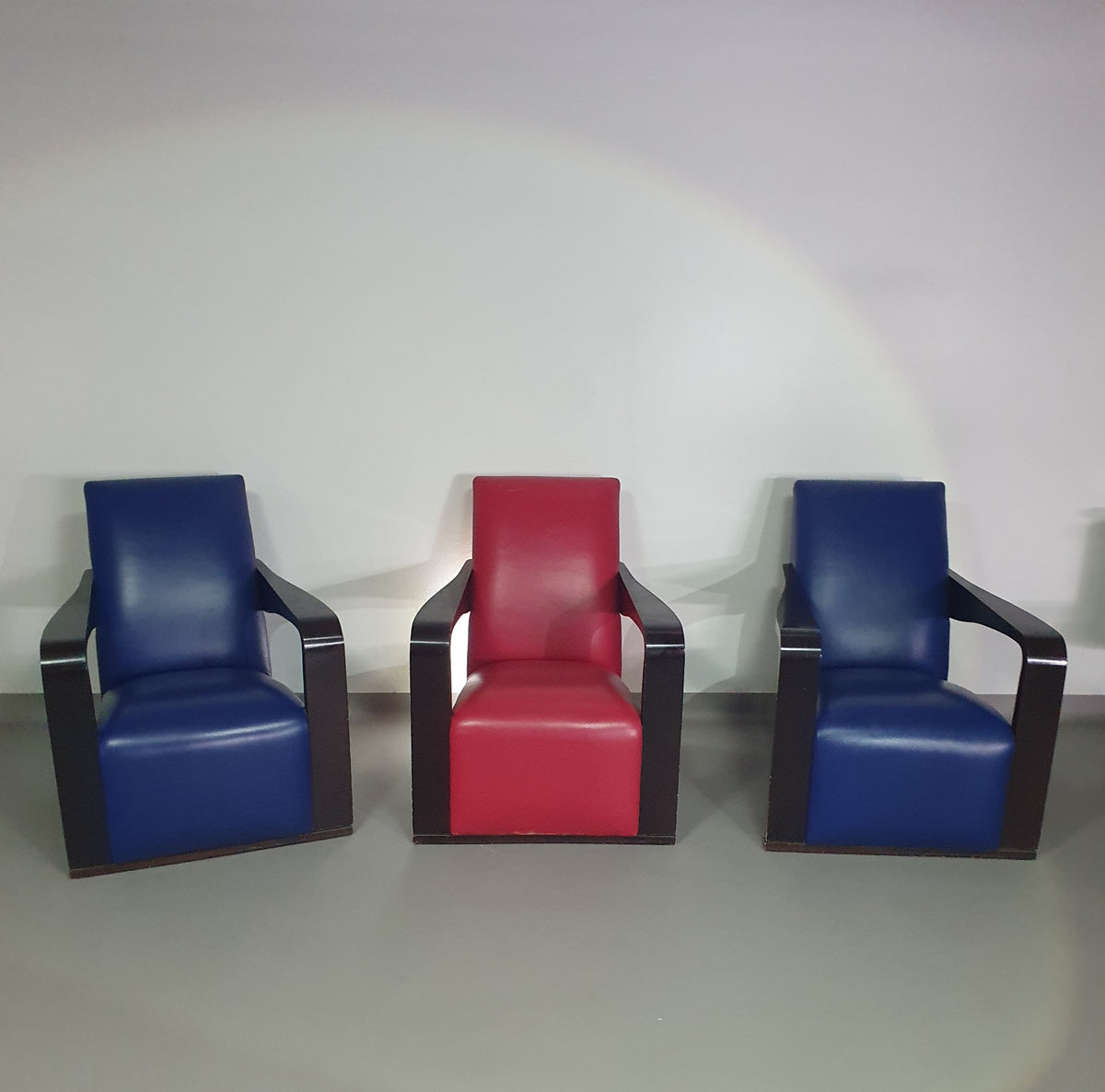 4 x Vintage Ying lounge chairs / fauteuils van Hugues Chevalier, jaren 1990. 3 x blue / 1 x red leather. Special made in these colours for Tommy Hilfiger. With traces of use.