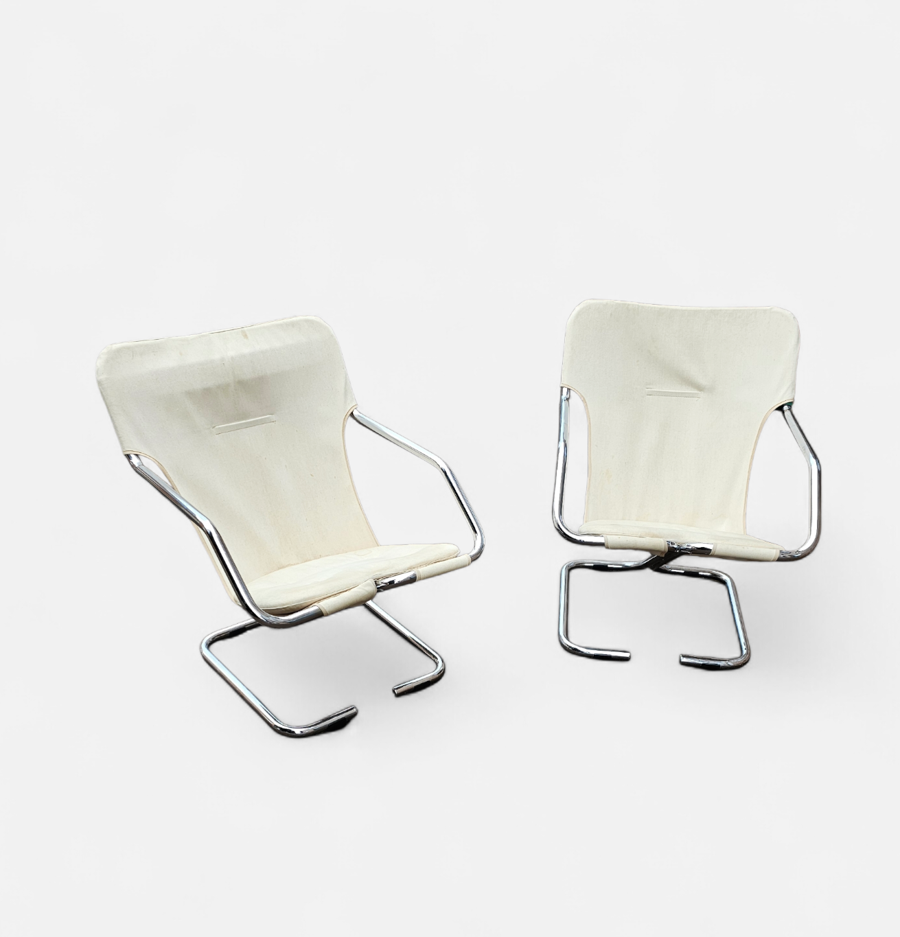 2 x Tubular chrome cantilever chair with a cream canvas sling