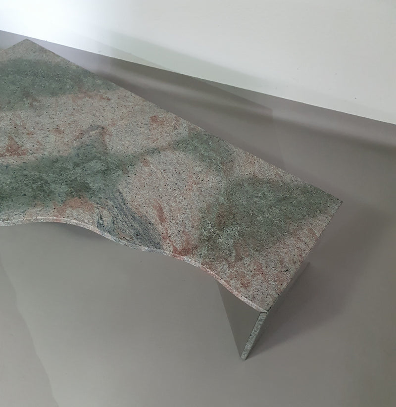 Een grote granieten salontafel met een vrije vorm, drie rechte lijnen die contrasteren met een golvend front. Jaren 70