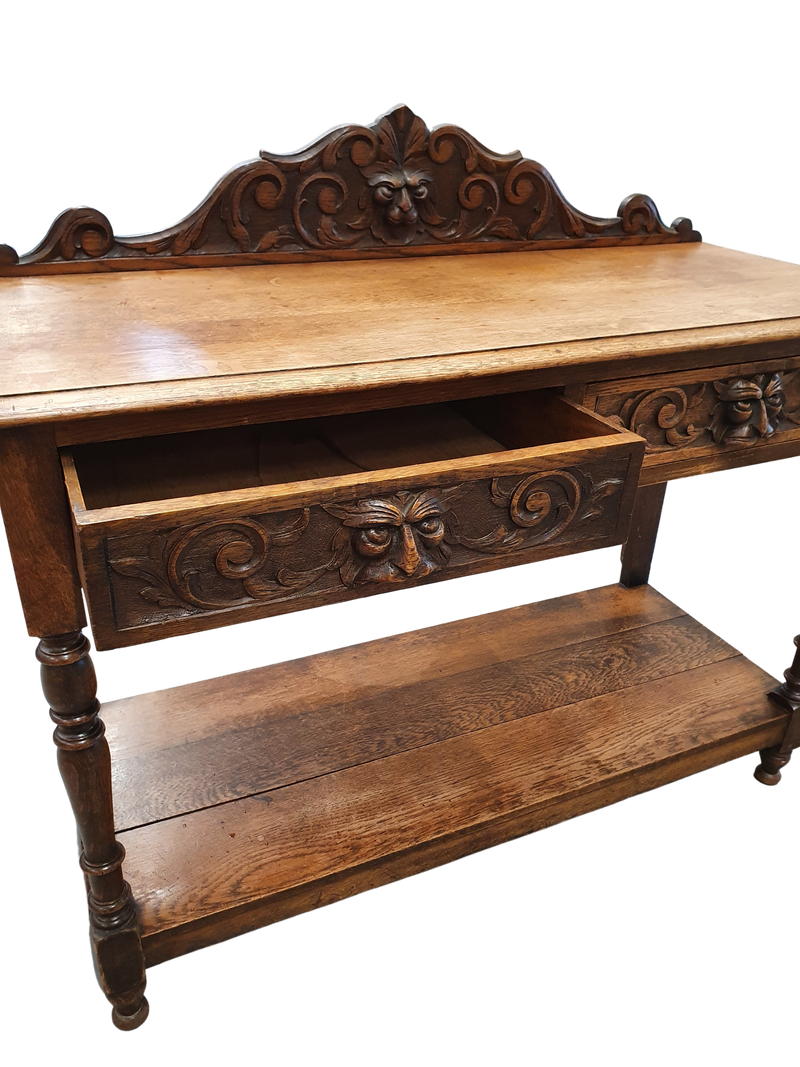Victoriaanse gotische eikenhouten bijzettafel, decoratief gesneden rond 1920. Groene maskerdecoratie