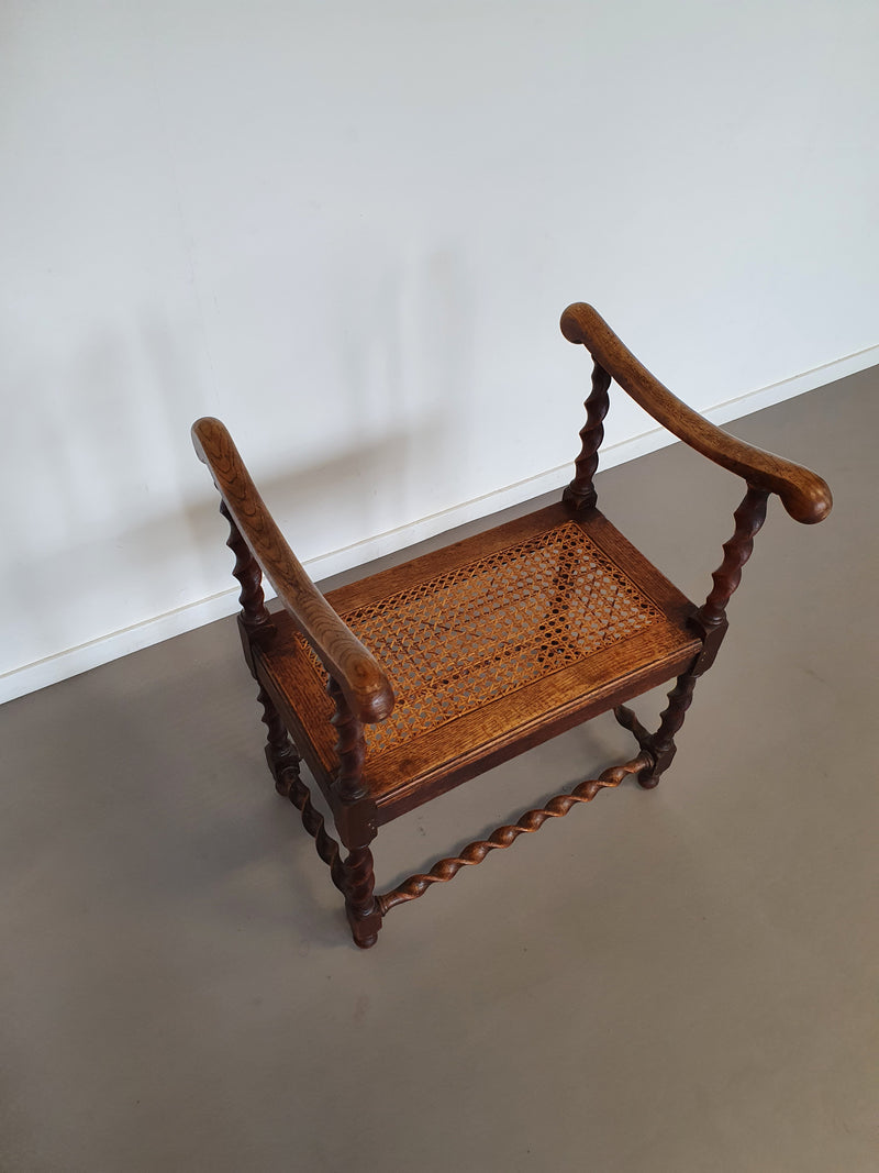 Wokkel stoel met armleuningen en webbing zitting.
