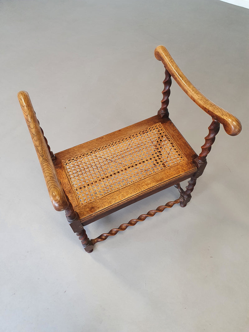 Wokkel stoel met armleuningen en webbing zitting.